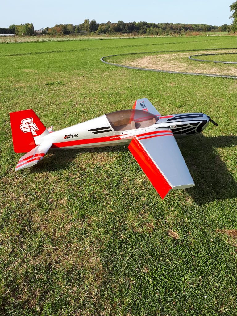 Avion de voltige rouge et blanc au terrain