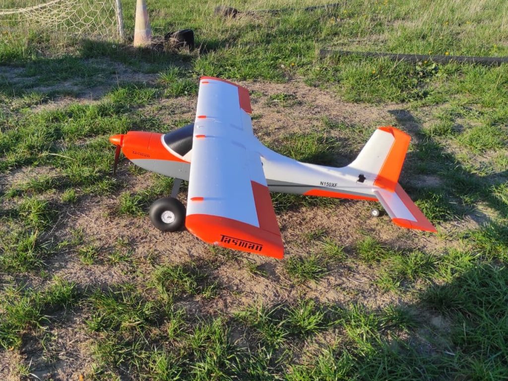 Avion orange et blanc posé sur le terrain