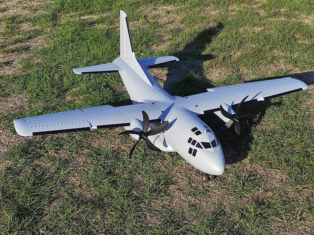 Bimoteur gris posé sur l’herbe du terrain